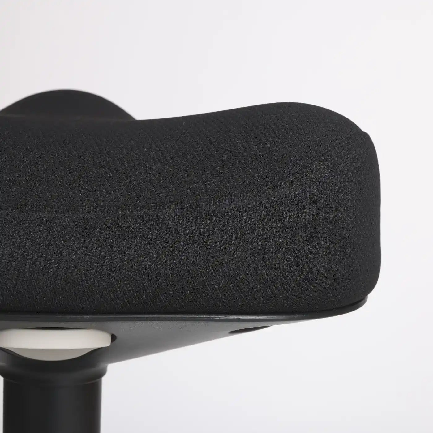 Close-up studio photo of a part of the seat of the Wobblez Soothe wobble stool in black and the grey knob visible on a neutral white grey background