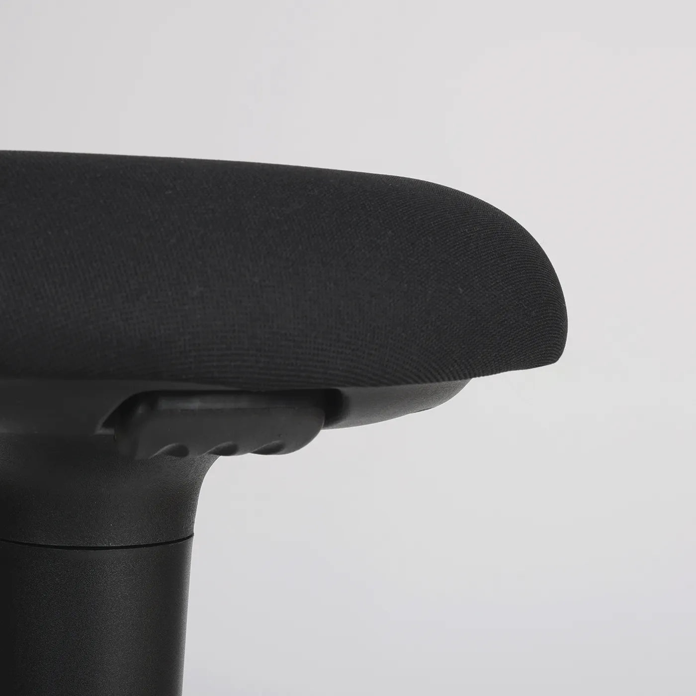 Close-up studio photo of a part of the seat of the Wobblez Spine wobble stool in black and the knob visible on a neutral white grey background