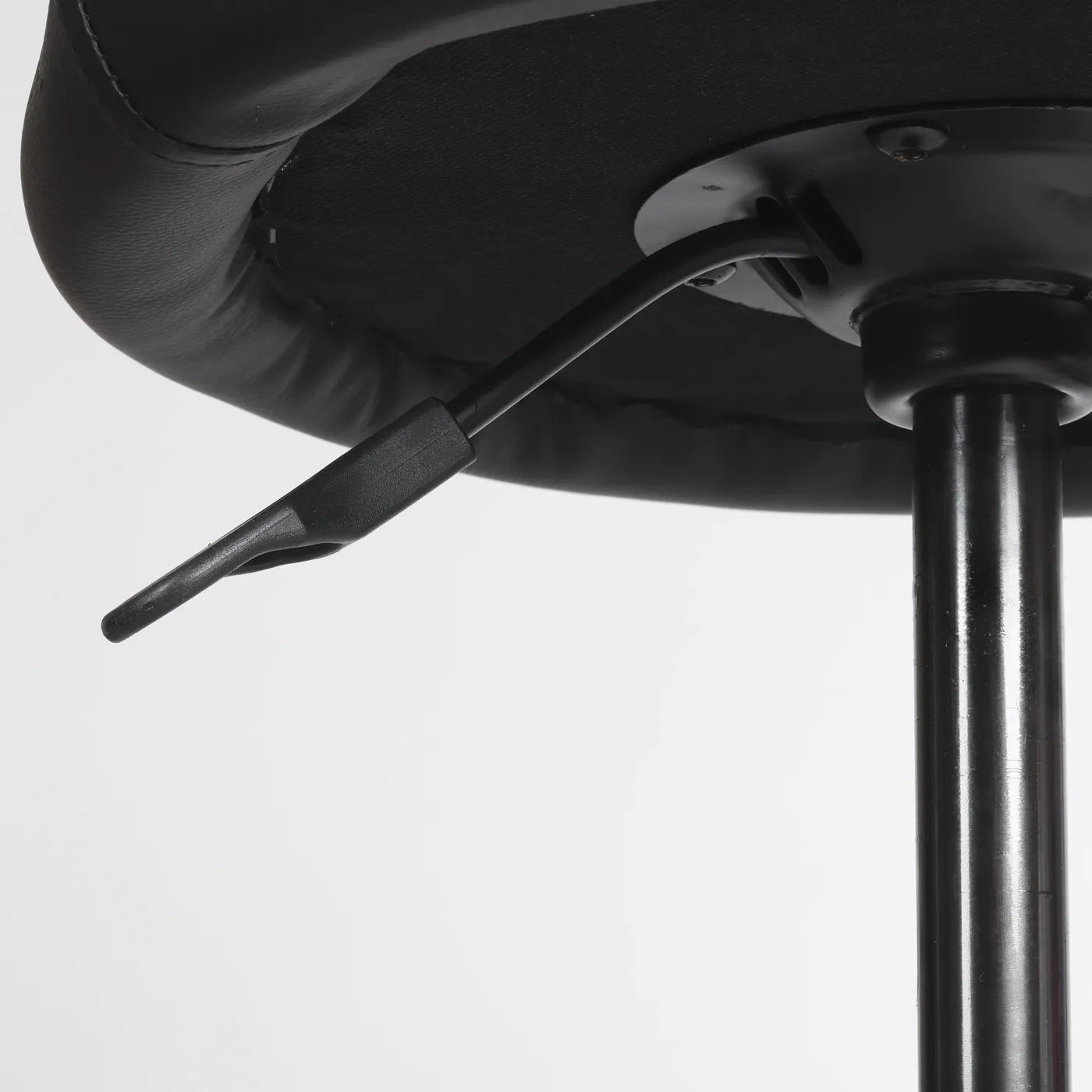 Close-up photography of handle lever to change the height from black Wobblez Settle wobble stool, a faux leather black office chair with a white background