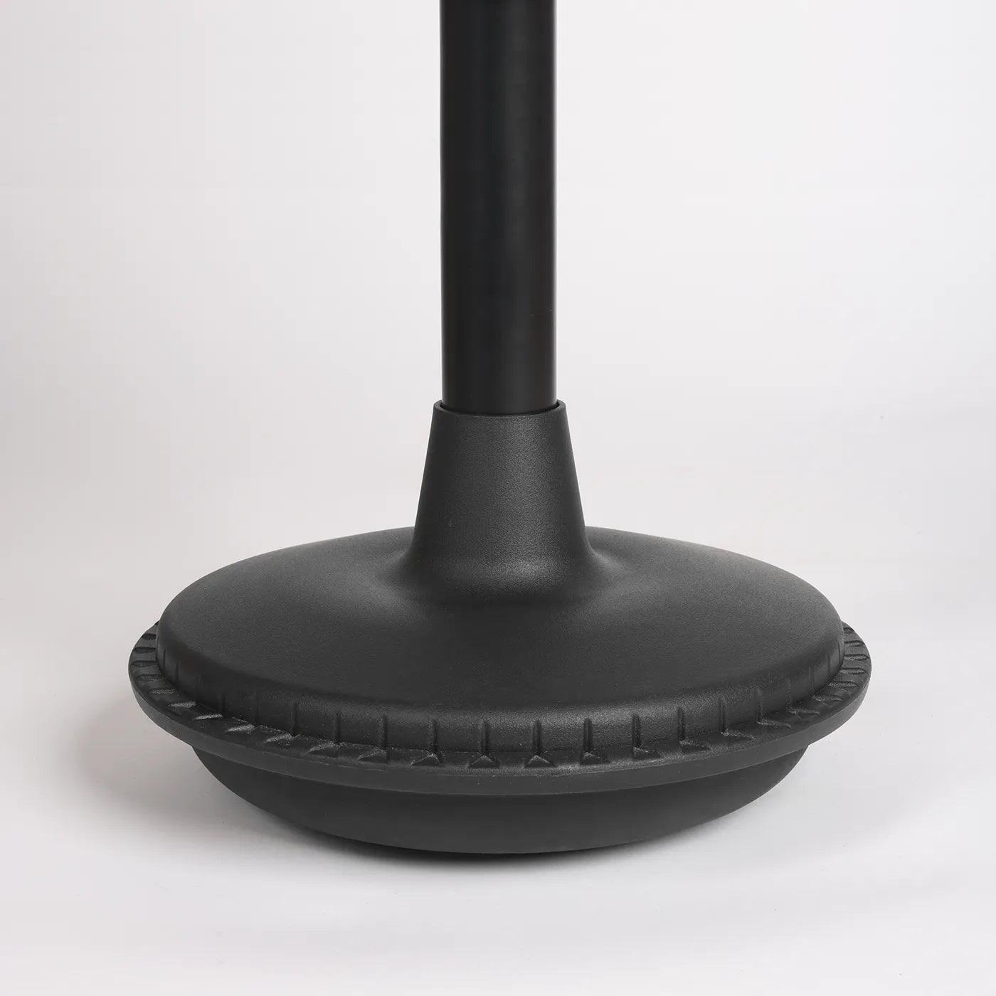 Close-up photography front straight view of foot from black Wobblez Settle, Stable or Spine wobble stool, a faux leather black office chair with a white background