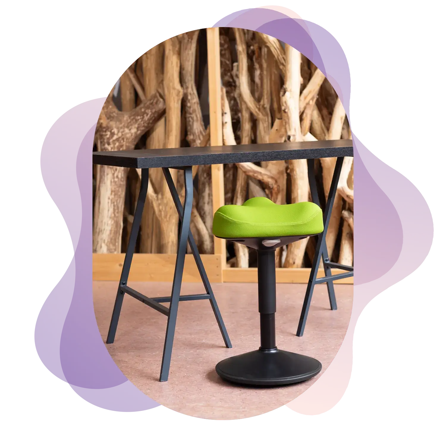 Image in the center of Wobblez graphic design styled blobs in purple with a black-green Soothe wobble stool in a studio at a wooden table with a wooden beams in the background