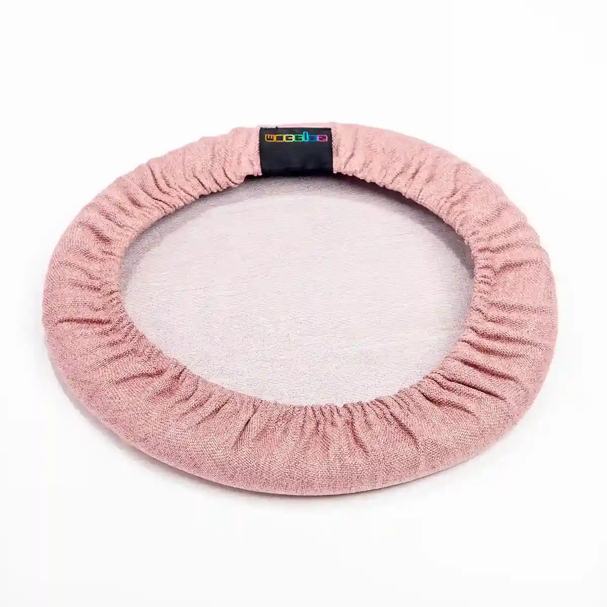Bottom view studio photography of Dusty Pink Wobblez Skins, a premium seat stool cover for Spine and Savvy wobble stools with a brand label on the edge on white background