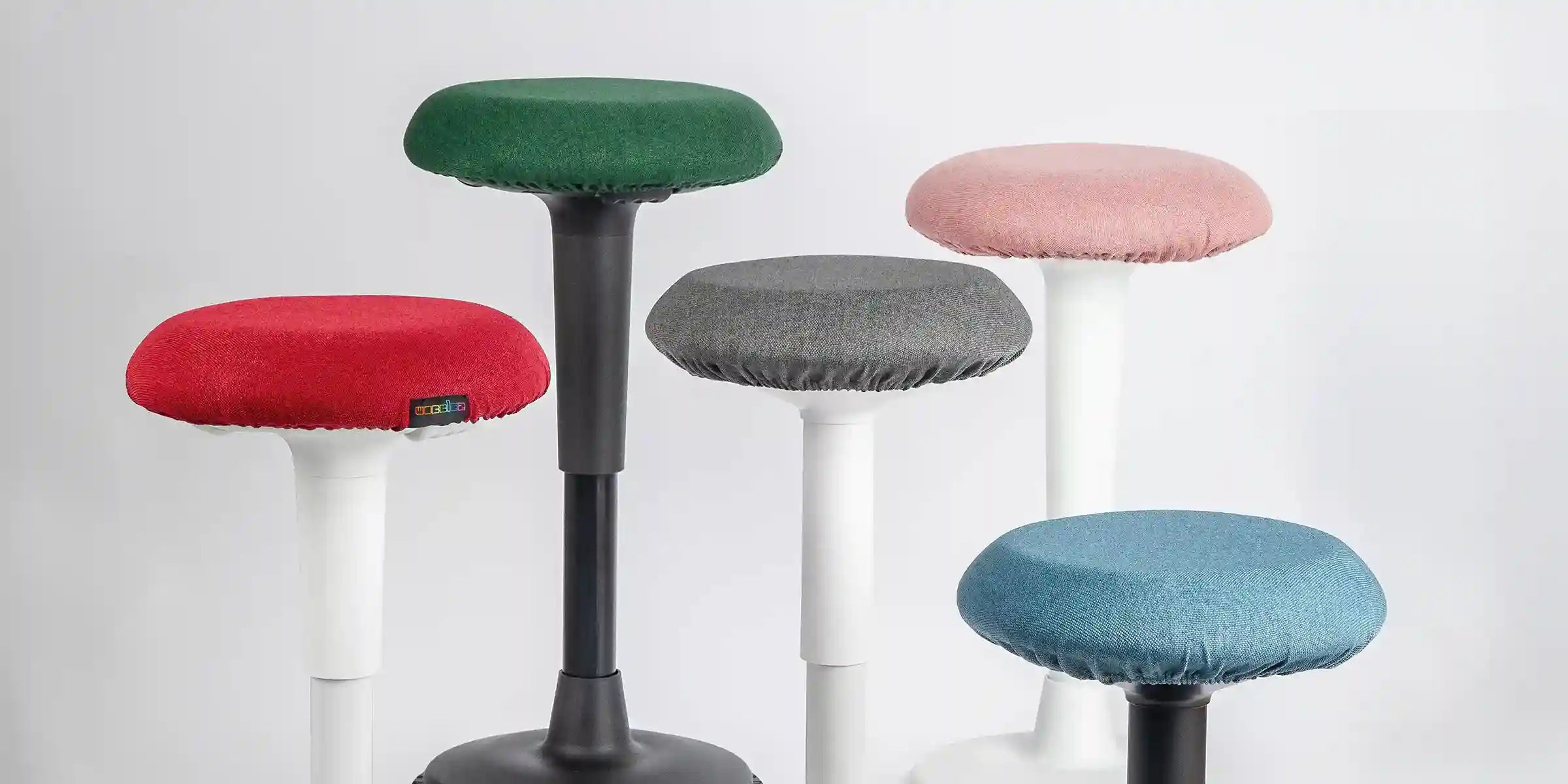 Set of Wobblez Spine and Savvy wobble stools with different colored Skins covers on a white background