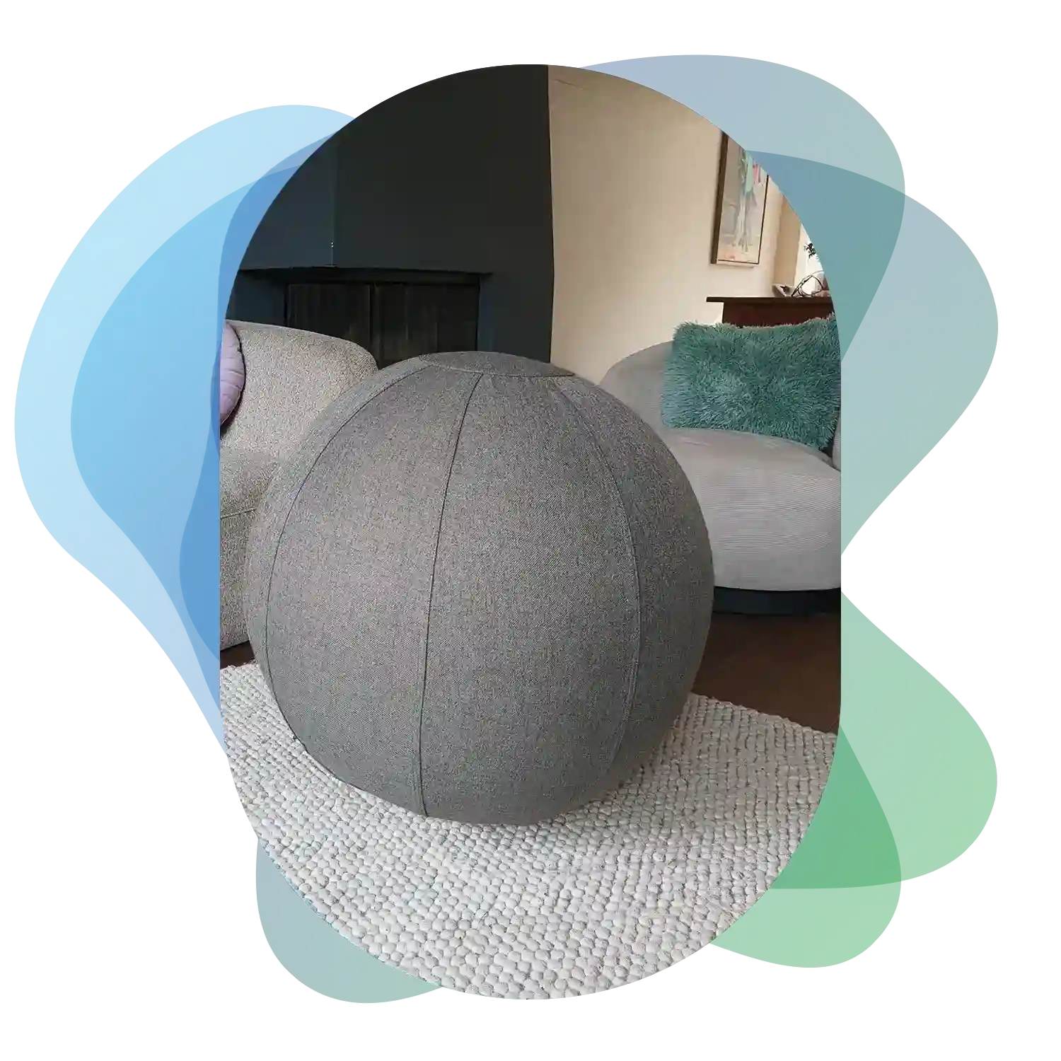 A gray 75cm fabric Wobblez exercise sitting ball sits on a textured white rug in a living room with a couch and cushions in the background.